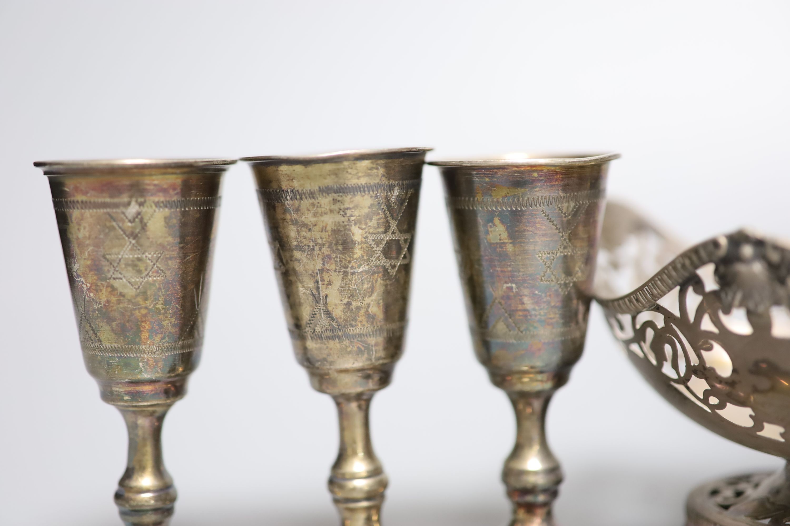 Five George V silver kiddush cups, a late Victorian silver goblet, a silver bonbon dish, silver salt, silver napkin ring and a plated sugar shovel